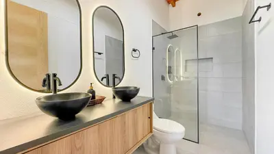 two sinks in a bathroom with two mirrors at Finca Monteverde House in San Isidro