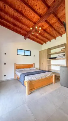 a bedroom with a bed with a wooden ceiling at Finca Monteverde House in San Isidro