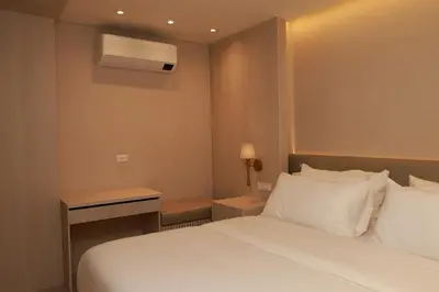 a hotel room with a white bed and a desk at VPV Suites & Casino in Medellín