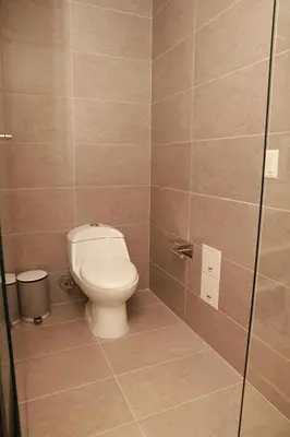 a bathroom with a toilet and a glass shower stall at VPV Suites & Casino in Medellín