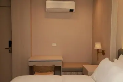 a hotel room with two beds and a desk and a bed sqor at VPV Suites & Casino in Medellín