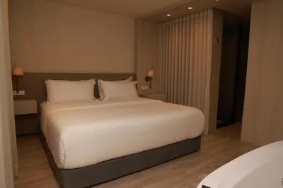 a bedroom with a large bed with white sheets and pillows at VPV Suites & Casino in Medellín