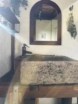 a bathroom with a stone sink and a mirror at Alto Bonito Cabin Salamina in Salamina