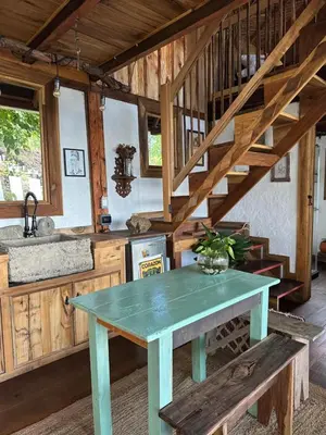 a kitchen with a table and a staircase in a cabin at Alto Bonito Cabin Salamina in Salamina
