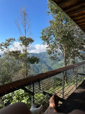 a person laying on a balcony looking out at the mountains at Alto Bonito Cabin Salamina in Salamina