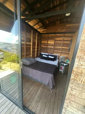 a bed in a small room with a balcony at SKY Glamping San Félix in Bello