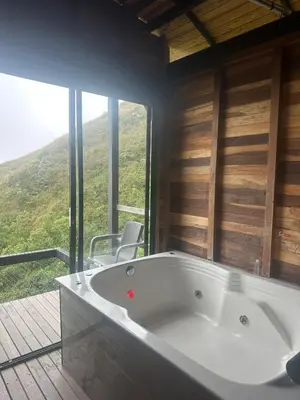 a bath tub in a room with a large window at SKY Glamping San Félix in Bello