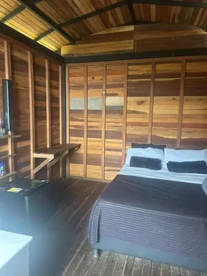 a bedroom with a bed in a wooden cabin at SKY Glamping San Félix in Bello