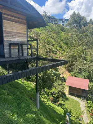 a bench sitting in the grass next to a building at SKY Glamping San Félix in Bello