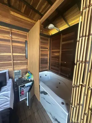 a large bath tub in a room with wooden walls at SKY Glamping San Félix in Bello