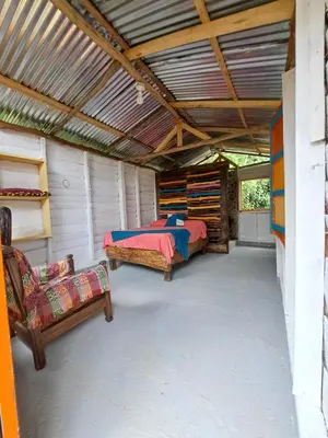 a bedroom with a bed and a couch in a room at Rocas del Rio Ecohotel in Mutatá