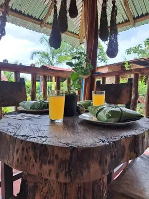 a wooden table with plates and glasses of orange juice at Rocas del Rio Ecohotel in Mutatá