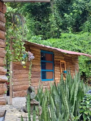 a small wooden house with a blue window at Rocas del Rio Ecohotel in Mutatá