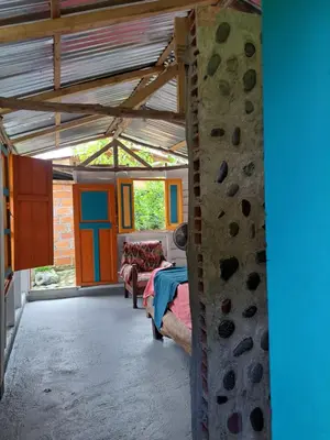 a living room with a couch and a rock wall at Rocas del Rio Ecohotel in Mutatá