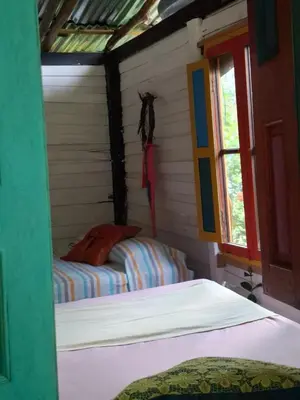 a bedroom with two beds in a room with a window at Rocas del Rio Ecohotel in Mutatá