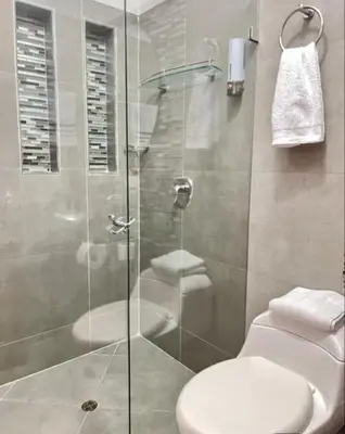 a bathroom with a glass shower with a toilet at Fami Hotel Luz de Luna in Jardin