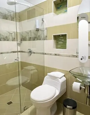 a bathroom with a toilet and a glass shower at Fami Hotel Luz de Luna in Jardin