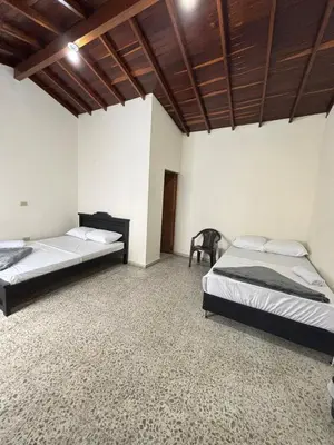 a bedroom with two beds and a wooden ceiling at Hospedaje Doña Blanca in Concepción