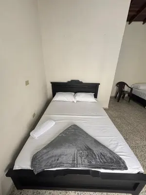 a bed in a small room with a mattress at Hospedaje Doña Blanca in Concepción