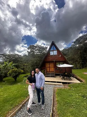a man and a woman standing in front of a cabin at Maderalia in El Salvador