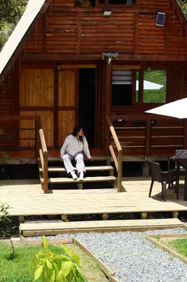 a person sitting on the steps of a cabin at Maderalia in El Salvador