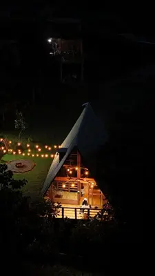 a tent is lit up at night with lights at Maderalia in El Salvador