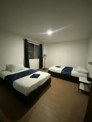 a bedroom with two beds and a window at Hotel el CONDADO in Itagüí