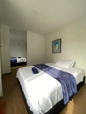 a hotel room with two beds in it at Hotel el CONDADO in Itagüí