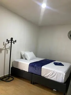 a bedroom with a bed with a cross on the wall at Hotel el CONDADO in Itagüí