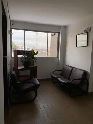 a waiting room with two chairs and a couch and a window at Hotel el CONDADO in Itagüí