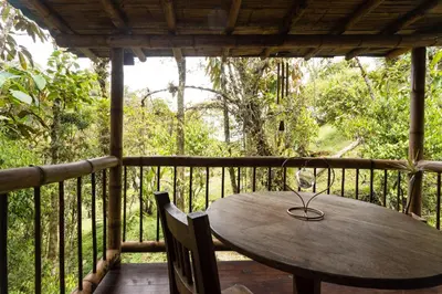a wooden table and chairs on a porch at El Santuario Retreat in Guatapé
