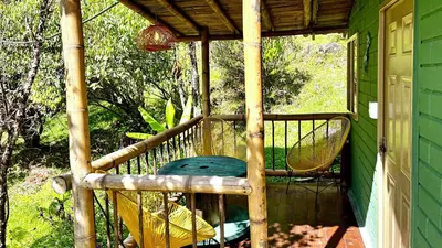 a porch with a swing and a chair at El Santuario Retreat in Guatapé