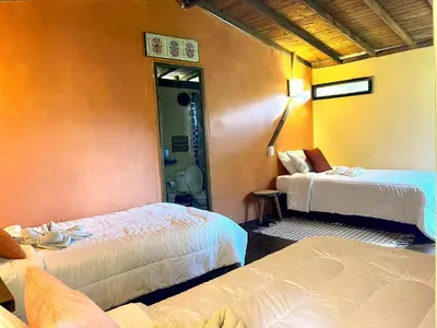 a hotel room with two beds and a bathroom at El Santuario Retreat in Guatapé