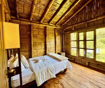a bedroom with a bed in a room with windows at El Santuario Retreat in Guatapé