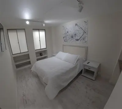 a white bedroom with a bed and two windows at Apartamento Manizales excelente ubicación in Manizales