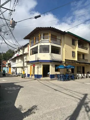a building on the corner of a street with tables and chairs at Hospedaje Doña Blanca 2 in Concepción