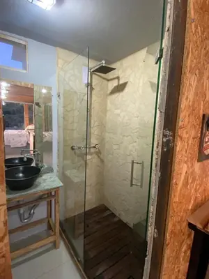 a shower with a glass door in a bathroom at Nakawe Guatape in Guatapé