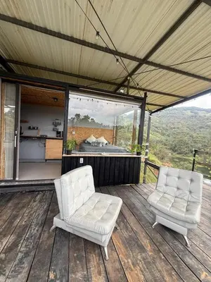 two white chairs sitting on a wooden deck at Nakawe Guatape in Guatapé