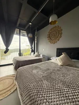 a bedroom with two beds and a large window at Nakawe Guatape in Guatapé