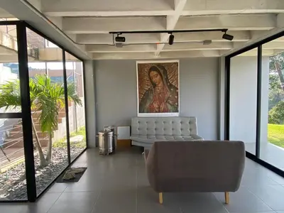 a living room with a couch and a painting on the wall at Nakawe Guatape in Guatapé