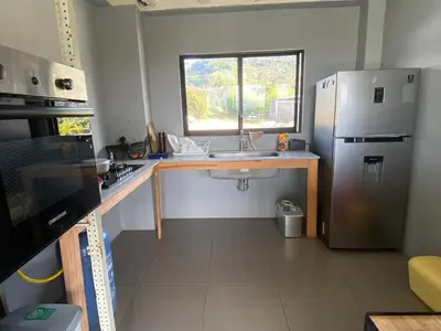 a small kitchen with a sink and a refrigerator at Nakawe Guatape in Guatapé