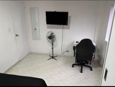 a room with a chair and a flat screen tv at Happy house in Medellín