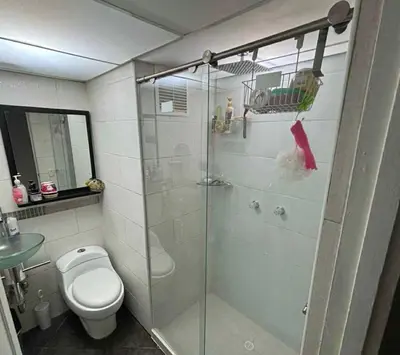 a bathroom with a toilet and a glass shower at Happy house in Medellín