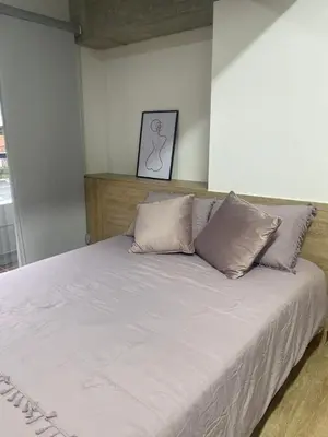 a bed with three pillows on it in a room at Hermoso apartamento tipo loft en El Retiro Oriente Ant in El Retiro