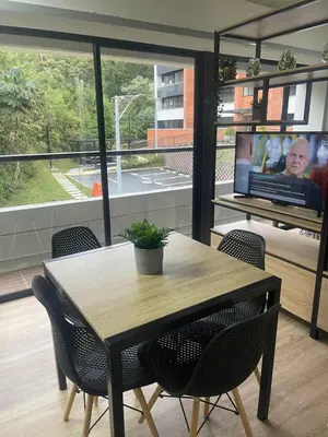 a table and chairs in a room with a television at Hermoso apartamento tipo loft en El Retiro Oriente Ant in El Retiro