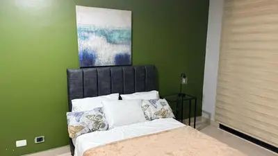 a bedroom with a bed with a painting above it at Bravas Medallo in Medellín