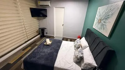 a bedroom with a bed with two pillows and a television at Bravas Medallo in Medellín
