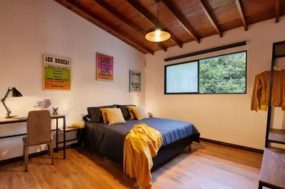 a bedroom with a bed and a desk and a window at El Poblado Medellin Luxury 5BR Jacuzzi AC in Medellín