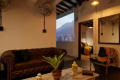 a living room with a brown couch and a mirror at El Poblado Medellin Luxury 5BR Jacuzzi AC in Medellín