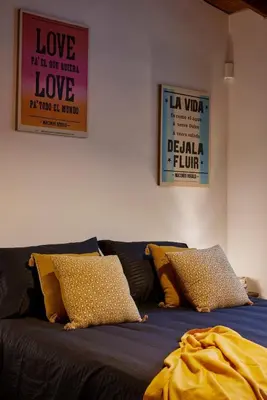 a black couch with yellow pillows and two posters at El Poblado Medellin Luxury 5BR Jacuzzi AC in Medellín